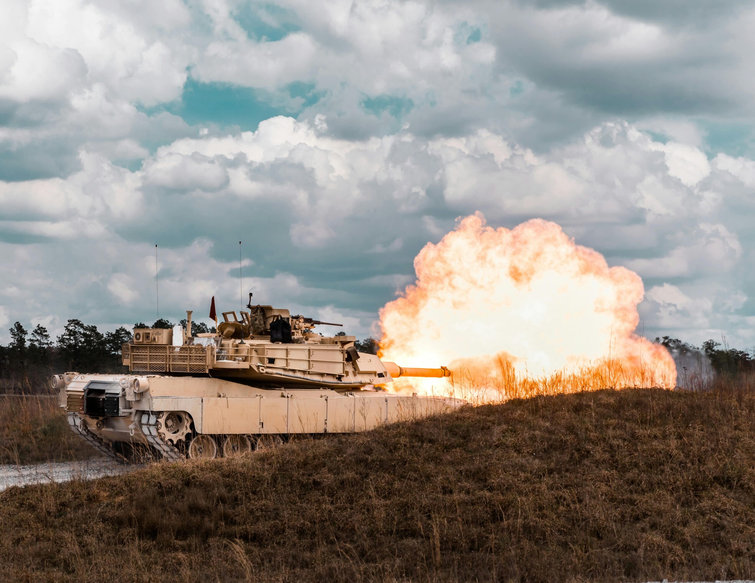 A military tank firing during a field exercise, showcasing its immense power and precision.