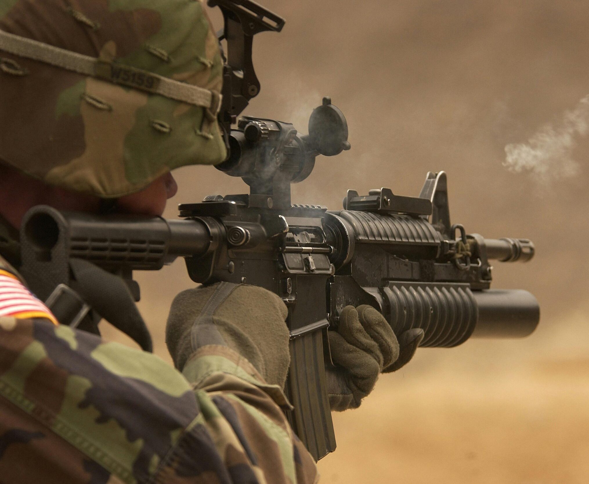 Close-up of a soldier in camo firing a rifle in action during training.